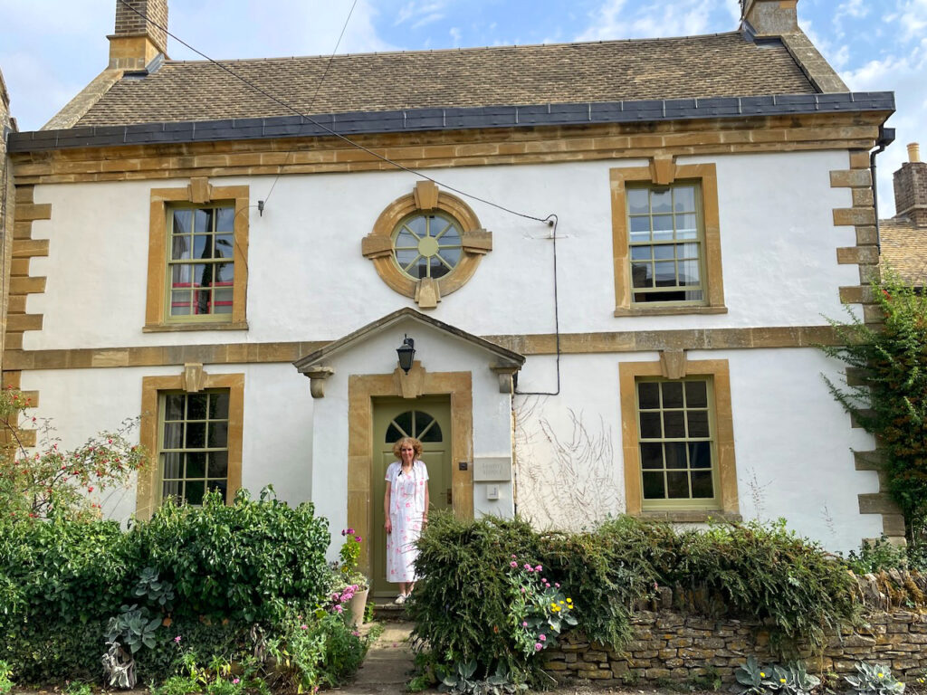 Jane proudly standing at front door of Sandys House, Chadlington