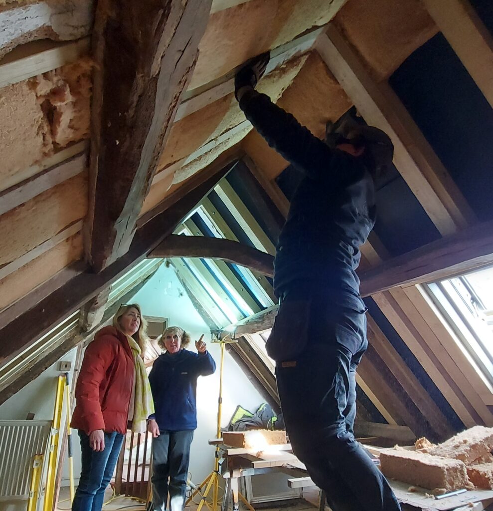 Jane (in middle) inspecting work being carried out in roof